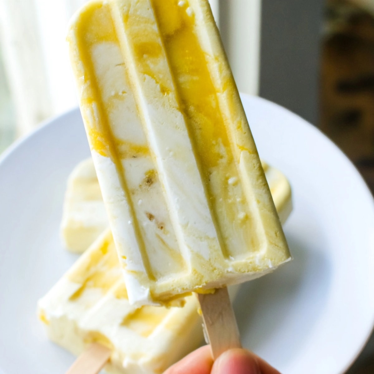 Creamy Mango Yogurt Banana Breakfast Pops, a vibrant swirl of fruit and yogurt, freezing solid.