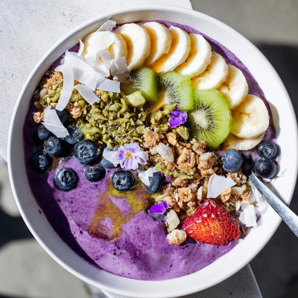 Vibrant smoothie bowls with pistachio and purple yam, topped with fresh fruit.  