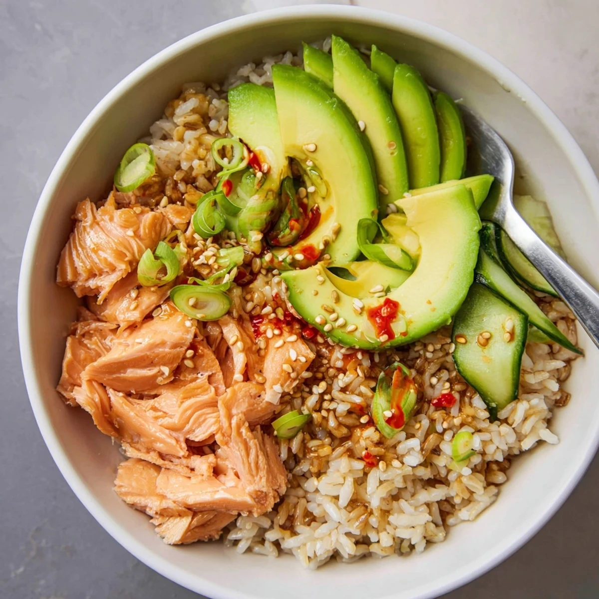 Hearty leftover salmon and rice bowl, garnished with pickled ginger and sesame seeds.
