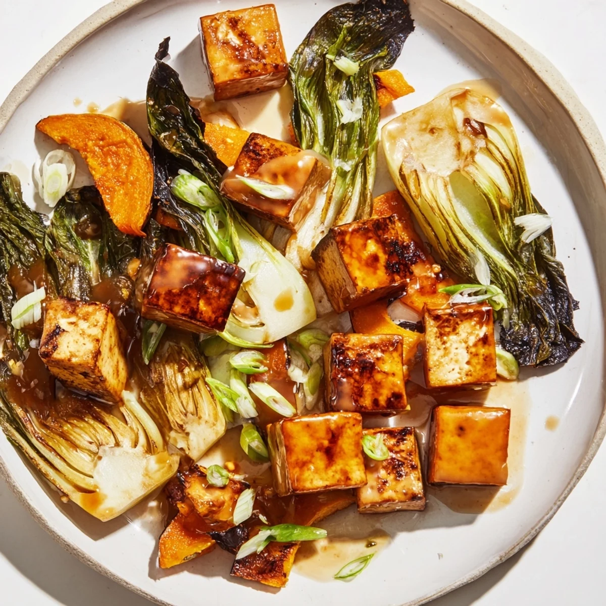 Savory miso glaze coats the caramelized tofu and squash in this flavorful recipe, ready to serve.