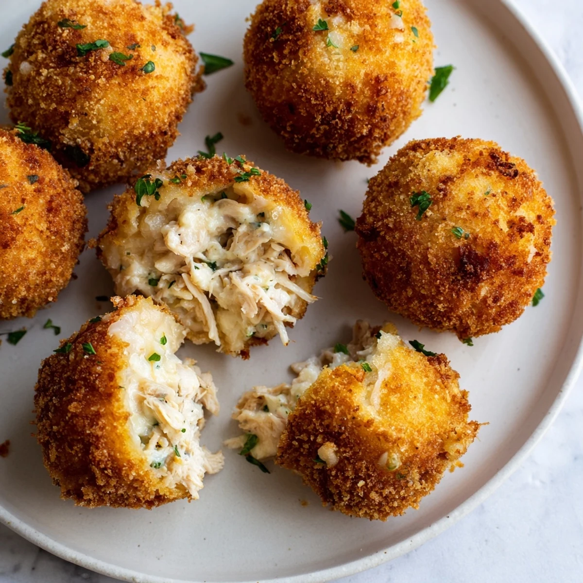 Golden-brown Creamy Chicken & Rice Arancini Balls ready to be served, a comforting Italian appetizer.