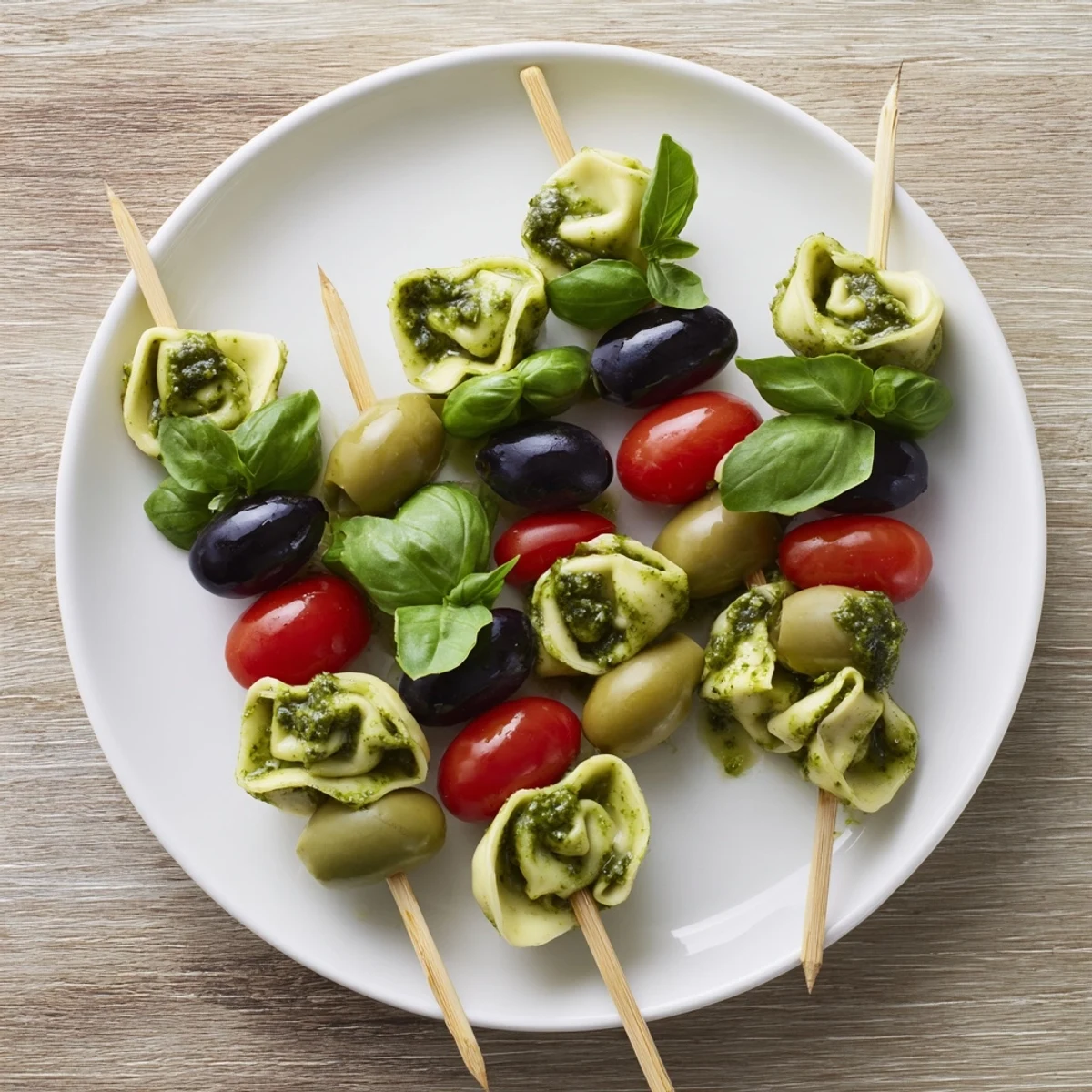 Appetizer Skewers showcasing colorful tortellini, vibrant pesto, olives, and fresh tomatoes, ready to enjoy.