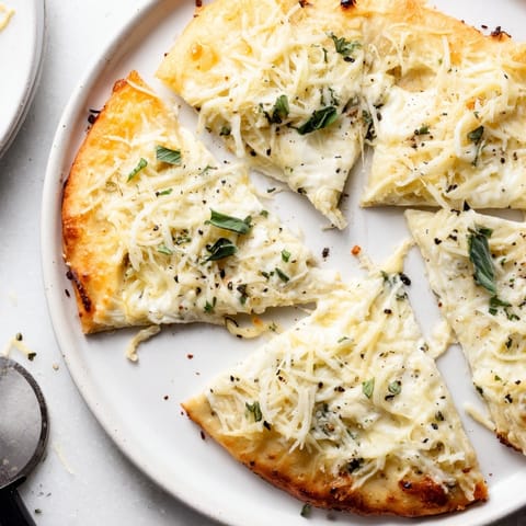 Homemade White Pizza: bubbly Parmesan, provolone, and garlic on a crispy baked crust.