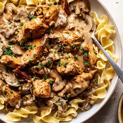 Creamy Chicken Stroganoff served over rich egg noodles garnished with fresh parsley.  