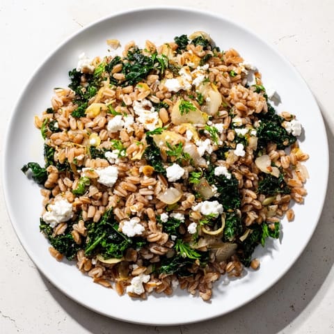 Enjoy a comforting serving of delicious Farro & Greens Pilaf, perfect for a vegetarian meal.