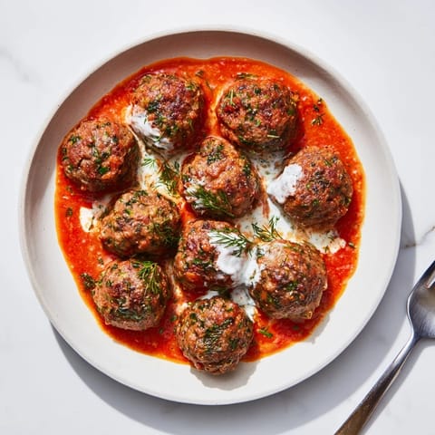 A close-up of tender Instant Pot Greek-Style Meatballs, simmering in tomato sauce, ready to serve.