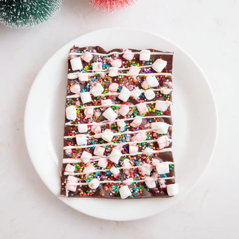 Homemade hot chocolate bomb bark with white chocolate drizzle, ready for cozy winter treats.