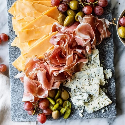 Visually stunning The Industrial Slate charcuterie board, with a striking assortment arranged on slate.
