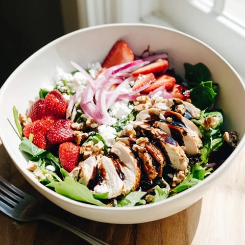 Juicy strawberries and crumbled feta top mixed greens with warm grilled chicken and a tangy balsamic drizzle.