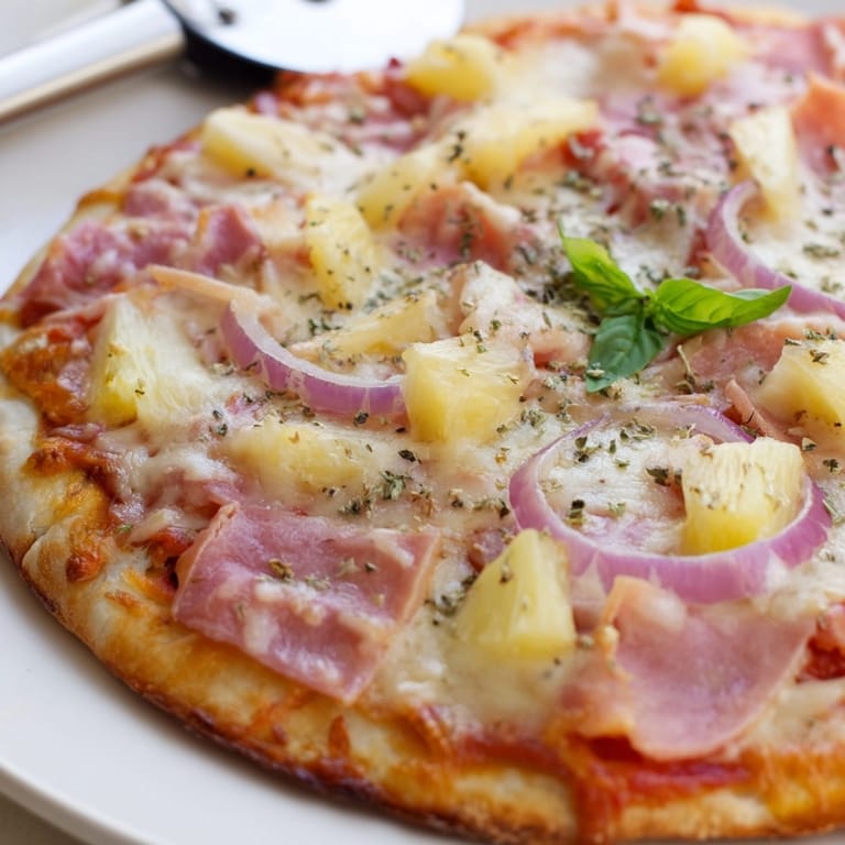 Baking a classic Hawaiian Pizza showcasing bubbly cheese, ham and sweet pineapple aroma.