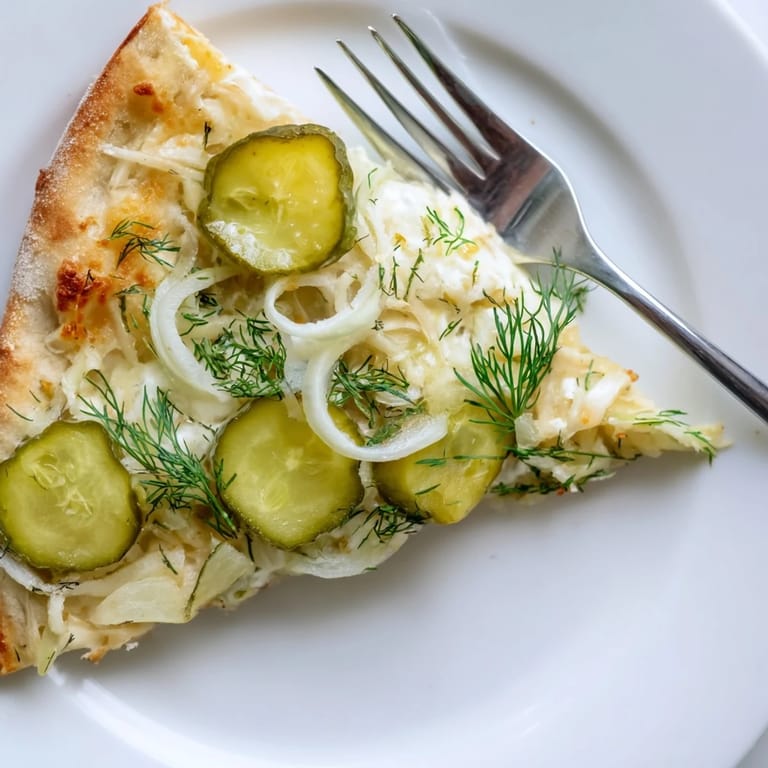 Vibrant Pickle Pizza showcasing creamy sauce, dill, and golden crust just baked.