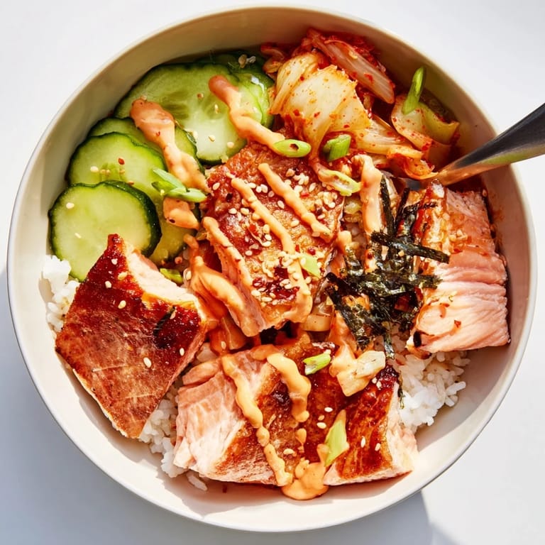 Savor this flavorful crispy salmon rice bowl drizzled with zesty mayo and fresh greens.