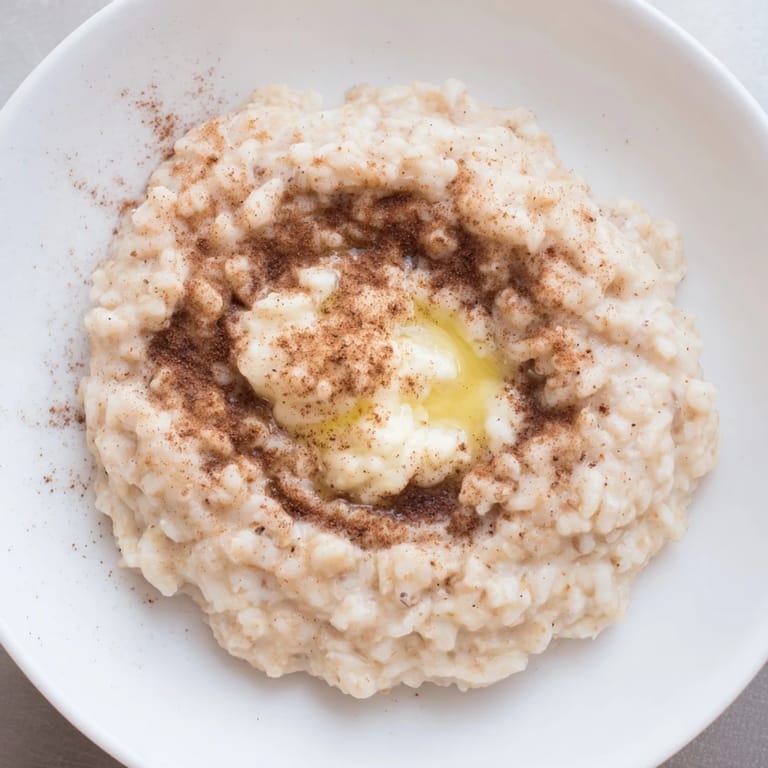 A comforting bowl of rice pudding made from leftover rice, subtly sweet and flavorful.