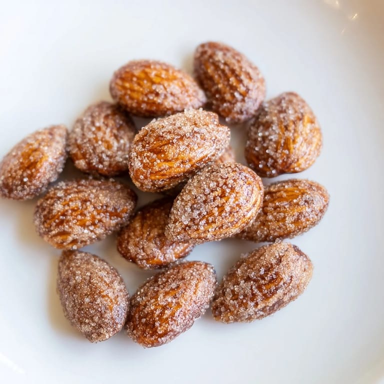 Close-up of crispy cinnamon roasted almonds, showing the cinnamon-sugar coating with a pleasant sheen.