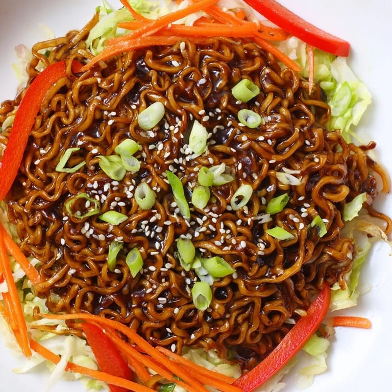 A flavorful bowl of Spicy Ramen Stir Fry, with glistening noodles and savory umami sauce.