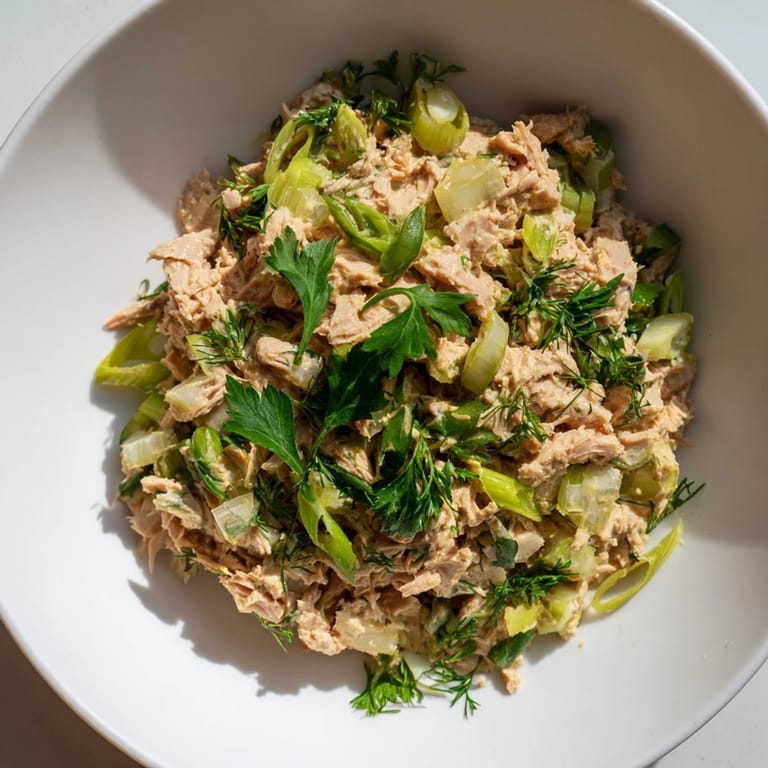 Bright serving suggestion for Spicy Zesty Tuna Salad, garnished with lemon wedges and parsley, perfect for scooping onto toasted bread.