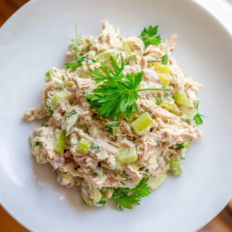 Freshly mixed bowl of Spicy Zesty Tuna Salad, highlighting the vibrant green scallions and a light, zesty lemon dressing.