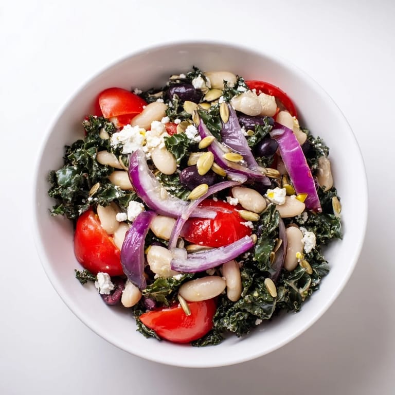 The White Bean and Kale Salad is served as a hearty vegetarian side dish, with red onion slices and a light, zesty Mediterranean-inspired dressing.  