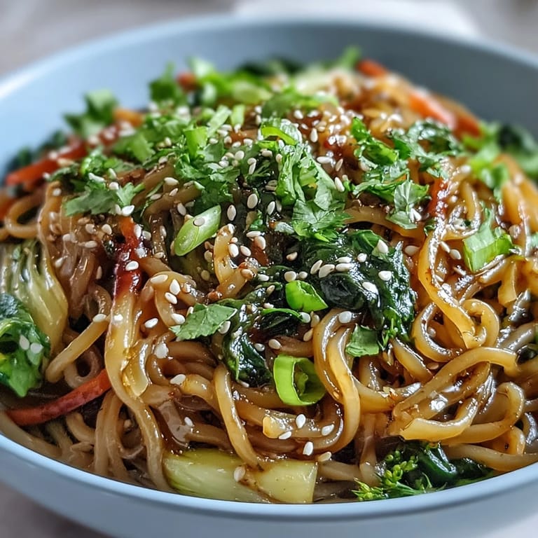 Stir-fried crisp Asian vegetables and shirataki noodles coated in a glossy ginger sauce in a white bowl.